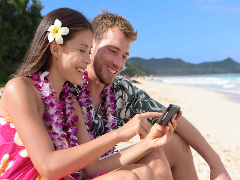 couple on beach looking at phone